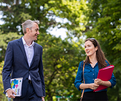 UCD student and staff member walking.